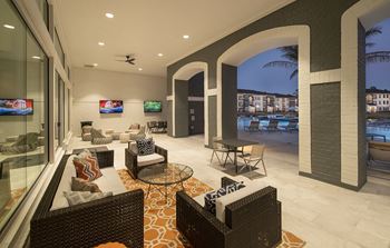 Outdoor Covered Patio with Soft Seating and TVs overlooking pool